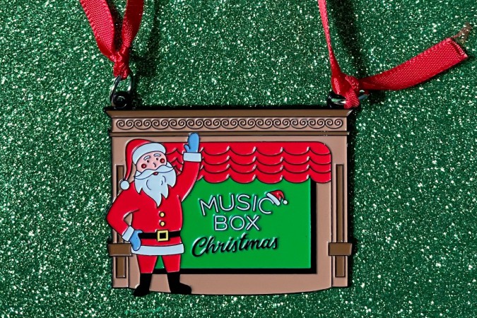 Music Box Christmas ornament featuring Santa Claus waving in front of the red curtain and stage
